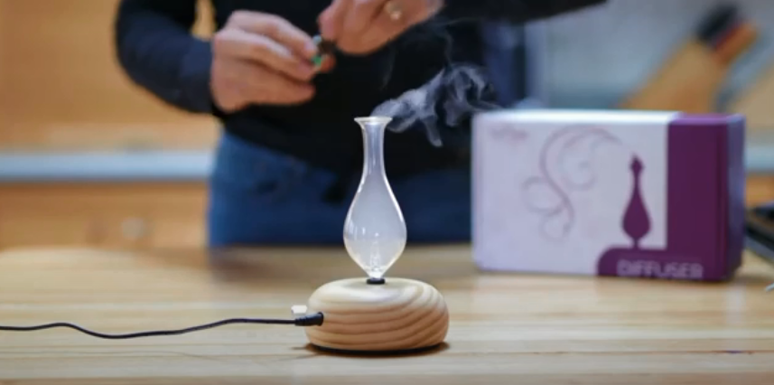 Working ArOmis Nebulizing Essential Oil Diffuser on a wooden tabletop