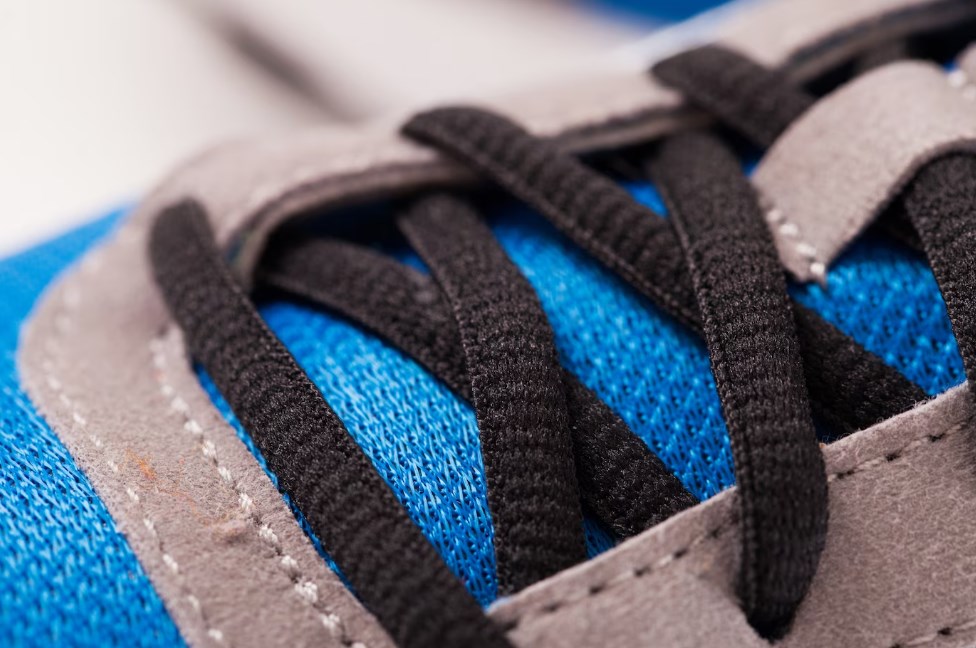 a close-up photo of blue-and-grey trainers with black laces