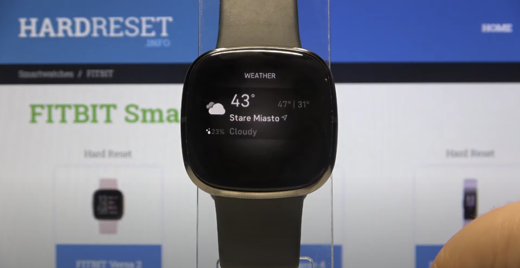 A black square smartwatch displaying the current weather on its screen.